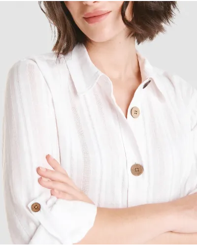 Mujer luce vestido largo abotonado color blanco con cuello camisero y sombrero de paja