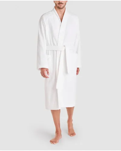 Man poses in unisex white cotton bathrobe with plaston pocket and belt