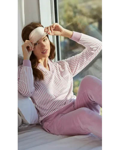 Woman wearing comfortable light pink microfleece pyjamas with a striped T-shirt and plain trousers