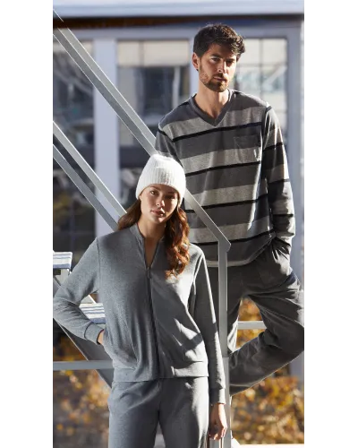 Mujer posando con conjunto de pijama gris chaqueta con cremallera y bolsillos y pantalón a juego.