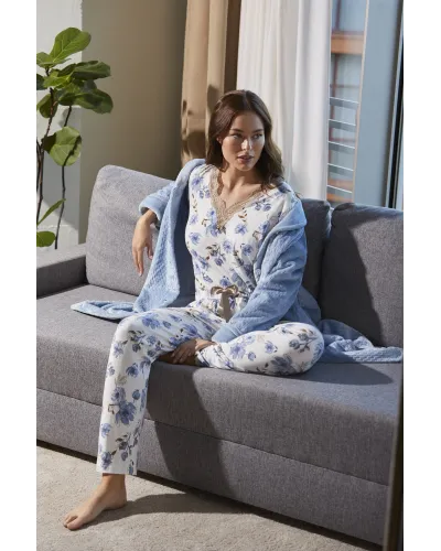 Woman wearing long-sleeved pyjamas with a blue floral print and a V-neckline with lace detailing.