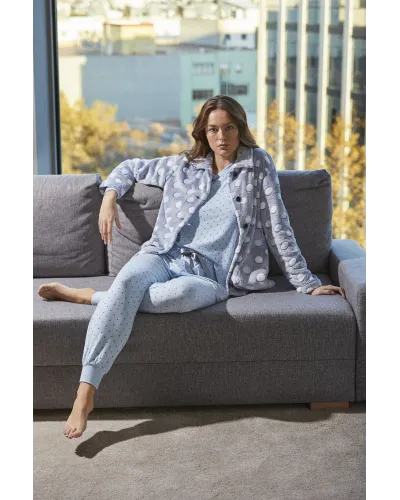 Mujer viste conjunto de pijama azul celeste de lunares y bata corta abotonada con bolsillos a juego