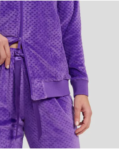 Woman wears comfortable purple tracksuit with zips