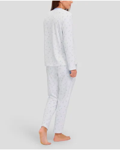 Woman in ivory winter pyjamas with light blue hearts and detailing on collar, pocket and cuffs