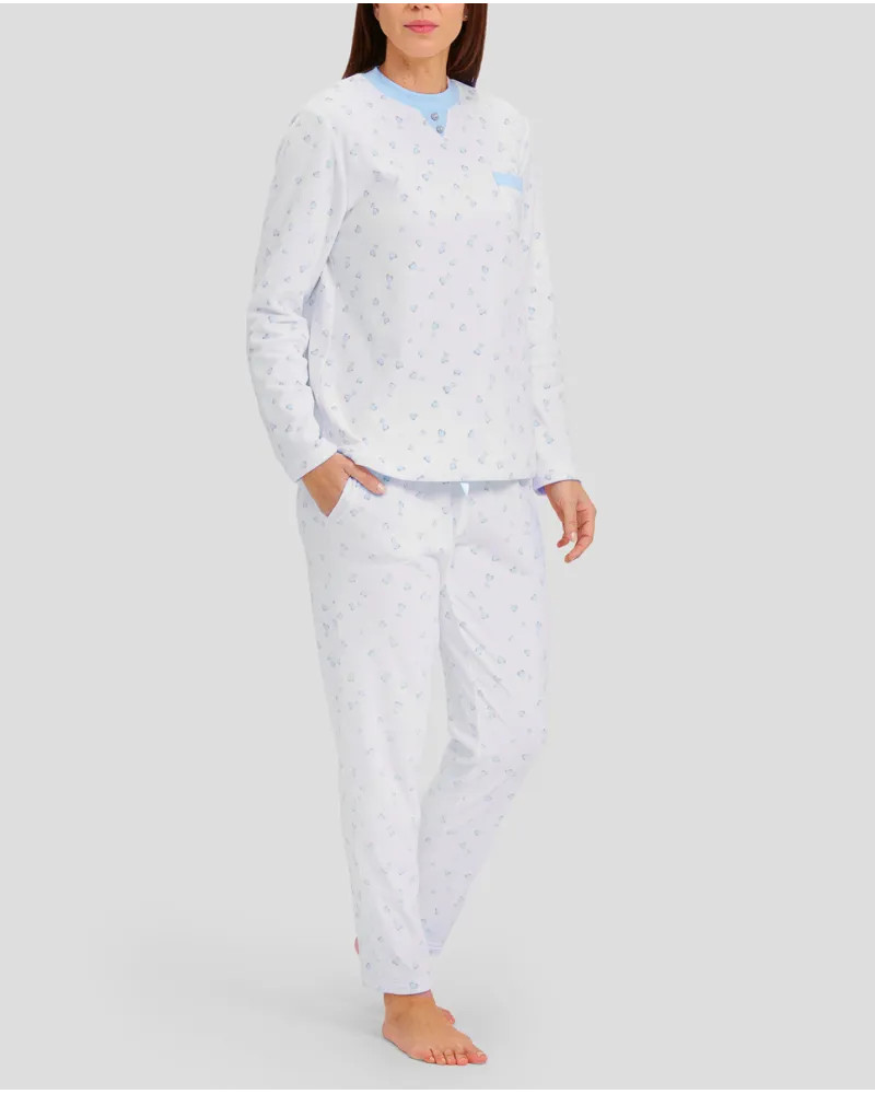 Woman in ivory winter pyjamas with light blue hearts and detailing on collar, pocket and cuffs