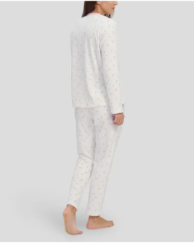 Woman in ivory winter pyjamas with pink hearts and detailing on collar, pocket and cuffs
