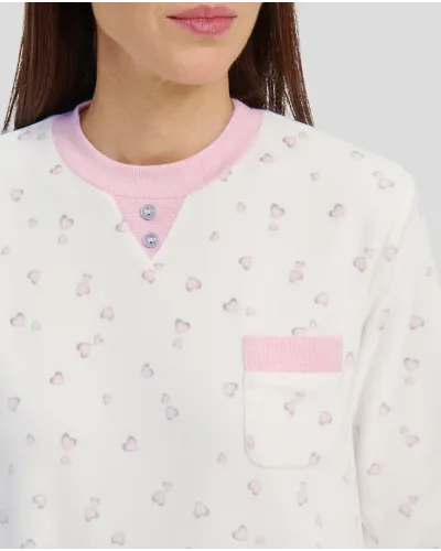 Woman in ivory winter pyjamas with pink hearts and detailing on collar, pocket and cuffs