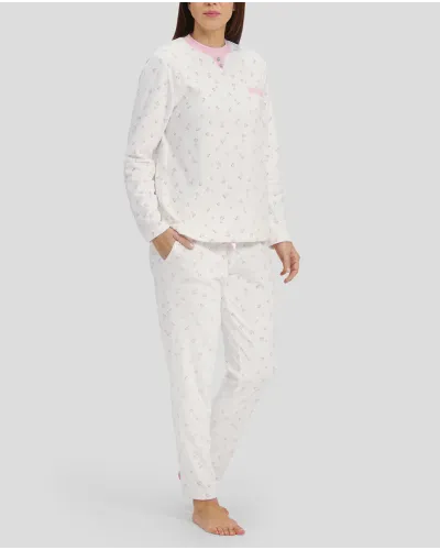 Woman in ivory winter pyjamas with pink hearts and detailing on collar, pocket and cuffs