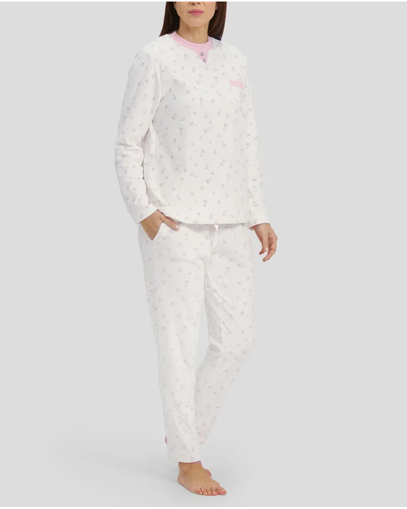 Woman in ivory winter pyjamas with pink hearts and detailing on collar, pocket and cuffs