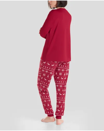 Woman in cosy and stylish red Christmas pyjamas with snowflake and reindeer patterns