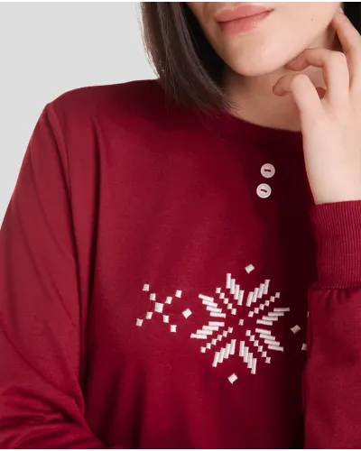 Woman in cosy and stylish red Christmas pyjamas with snowflake and reindeer patterns