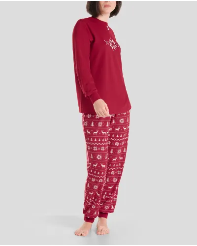 Woman in cosy and stylish red Christmas pyjamas with snowflake and reindeer patterns