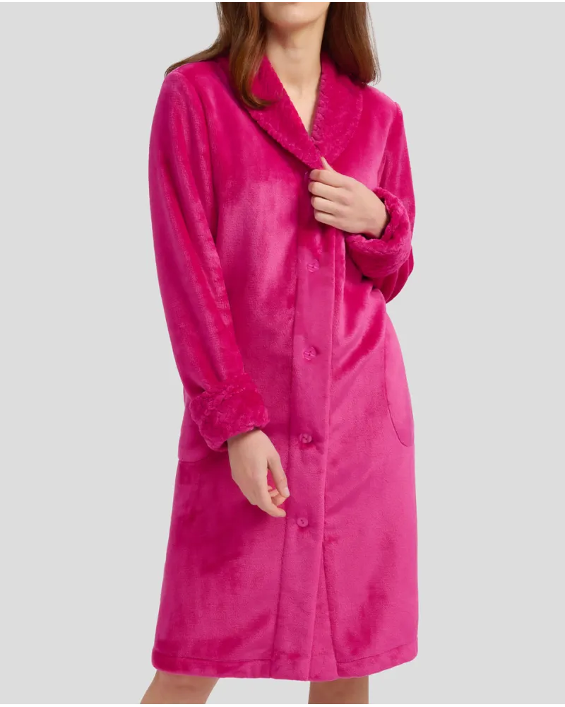 Woman in fuchsia flannel long dressing gown, buttoned and with pockets for winter