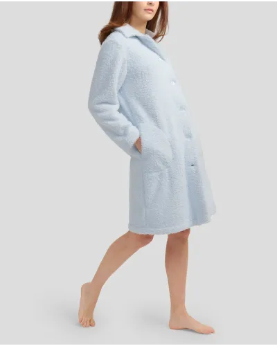 Woman with long sky blue sheepskin coat with buttoned buttons and pockets