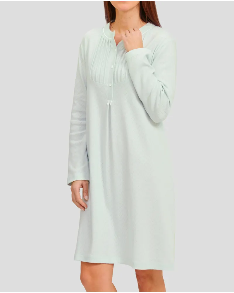 Woman in soft green long-sleeved nightgown for winter with louvers