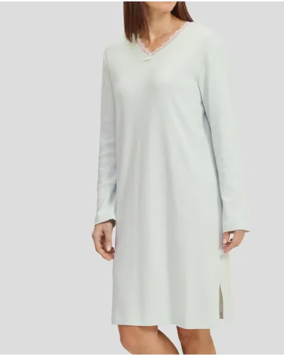Woman in ivory long-sleeved winter lingerie nightdress with V-neck and lace collar