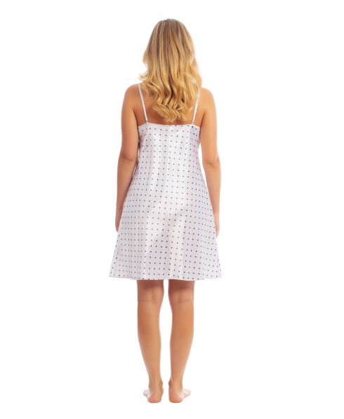 Woman wears a short white satin nightgown with polka dots.