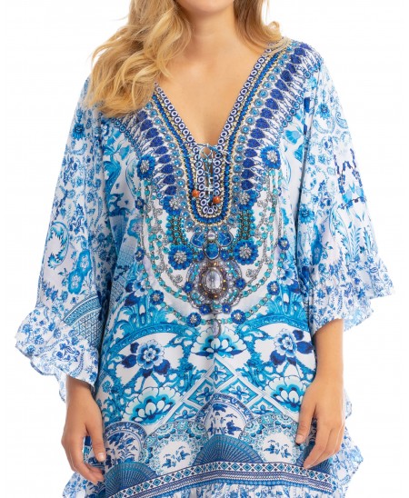 Detail of the summer printed kaftan in blue tones and open collar with trimmings.