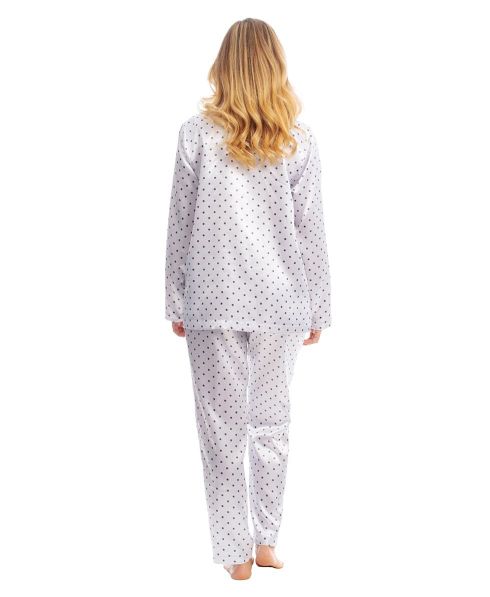 Woman in elegant long winter pyjamas in white satin with polka dot pattern
