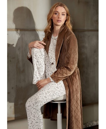 Seated woman in long brown winter dressing gown with diamond patterned dinner jacket collar