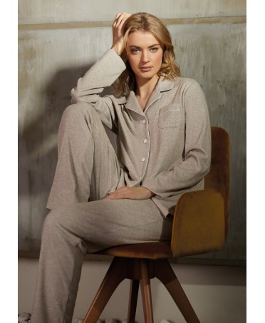 Woman seated in her plain brown winter pyjamas with piping