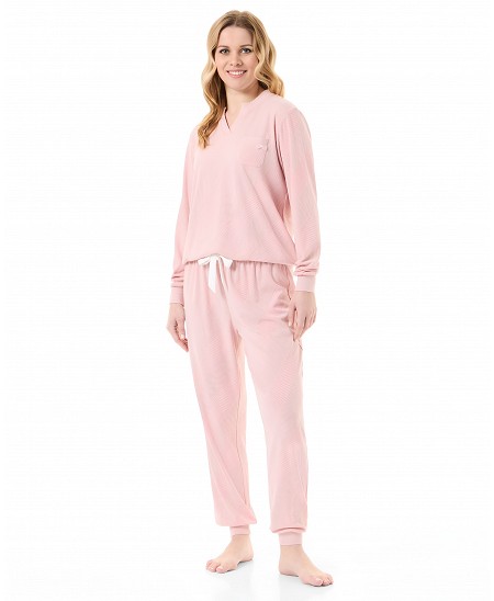 Mujer con pijama de invierno con chaqueta de manga larga, cuello de pico en canalé rosa y pantalón con bolsillos