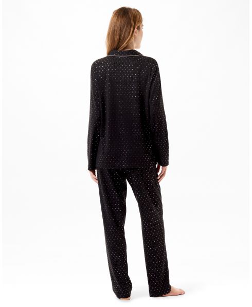 Rear view of a model wearing long black shirt pyjamas with silver polka dots, ideal for celebrations.