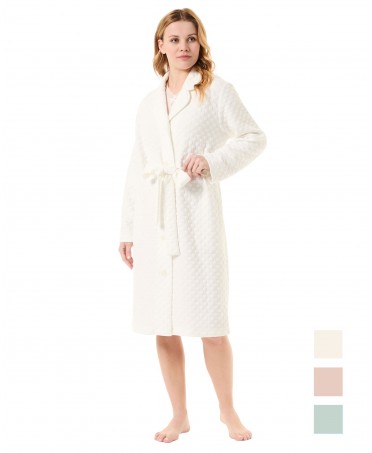 Woman in ivory-coloured open long dressing gown with circular knitted buttons