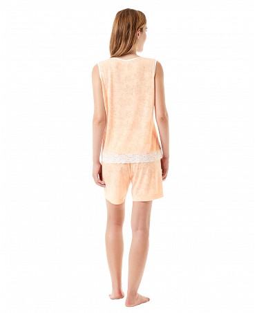 Vista trasera de una mujer luciendo un conjunto de pijama corto de verano de color naranja con puntilla.