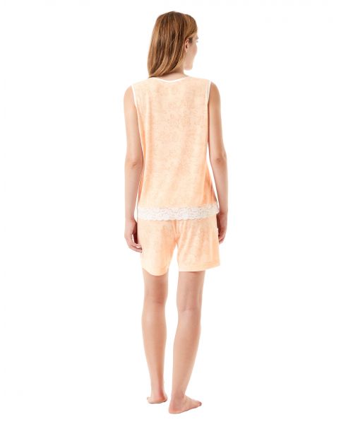 Rear view of a woman wearing an orange summer pyjama set with lace trim.