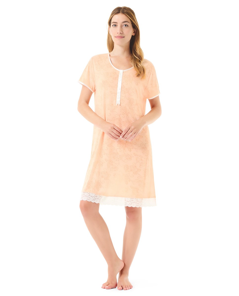 A woman wears a short summer nightgown in orange/peach coloured fabric.