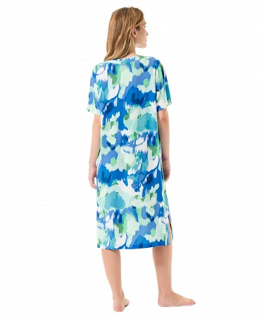 Woman with her back to the camera poses in a short summer dress with short sleeves and a blue water print.