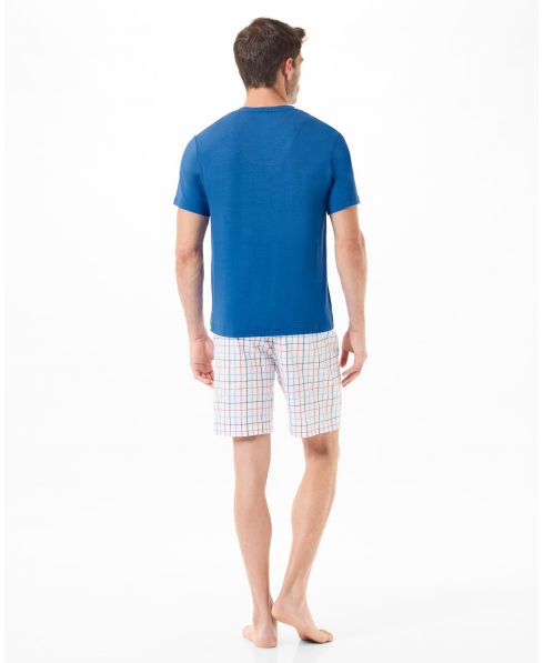 Rear view of a man in blue summer pyjama shorts and checkered trousers set
