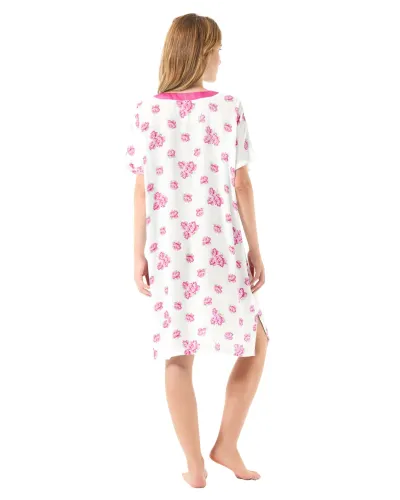 Una mujer luciendo un camisón corto blanco con flores color fucsia y cuello de raso a juego.