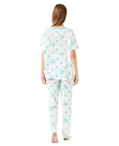 View of a woman's back with long floral pyjamas in turquoise blue tones.