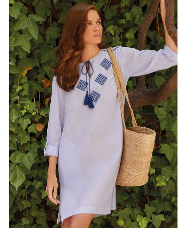 Woman poses with a summer dress with long sleeves gathered and embroidery on the neck