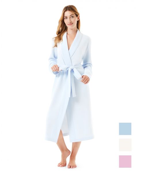 A woman wears a short, light blue dressing gown with pockets.