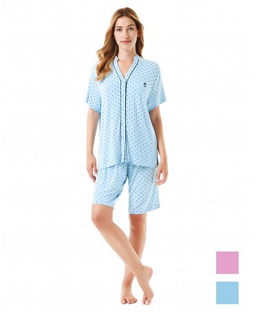 A woman wears a blue short-sleeved pyjama set with little hearts.