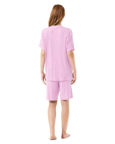 A woman wears a pink short-sleeved pyjama set with little hearts.