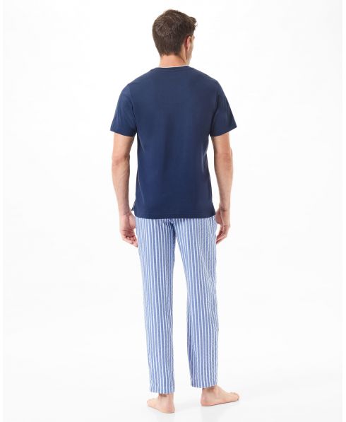 Man in summer pyjamas with striped long trousers and navy T-shirt on his back
