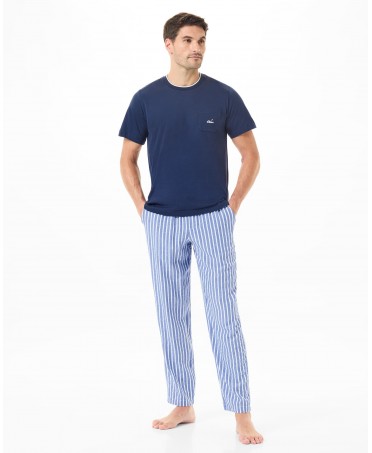 A man wearing pyjamas with striped trousers and a navy blue T-shirt.