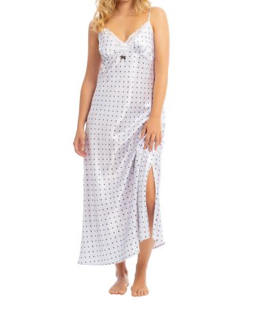 Woman with long white christmas nightdress in satin with polka dot print and lace trim at neckline