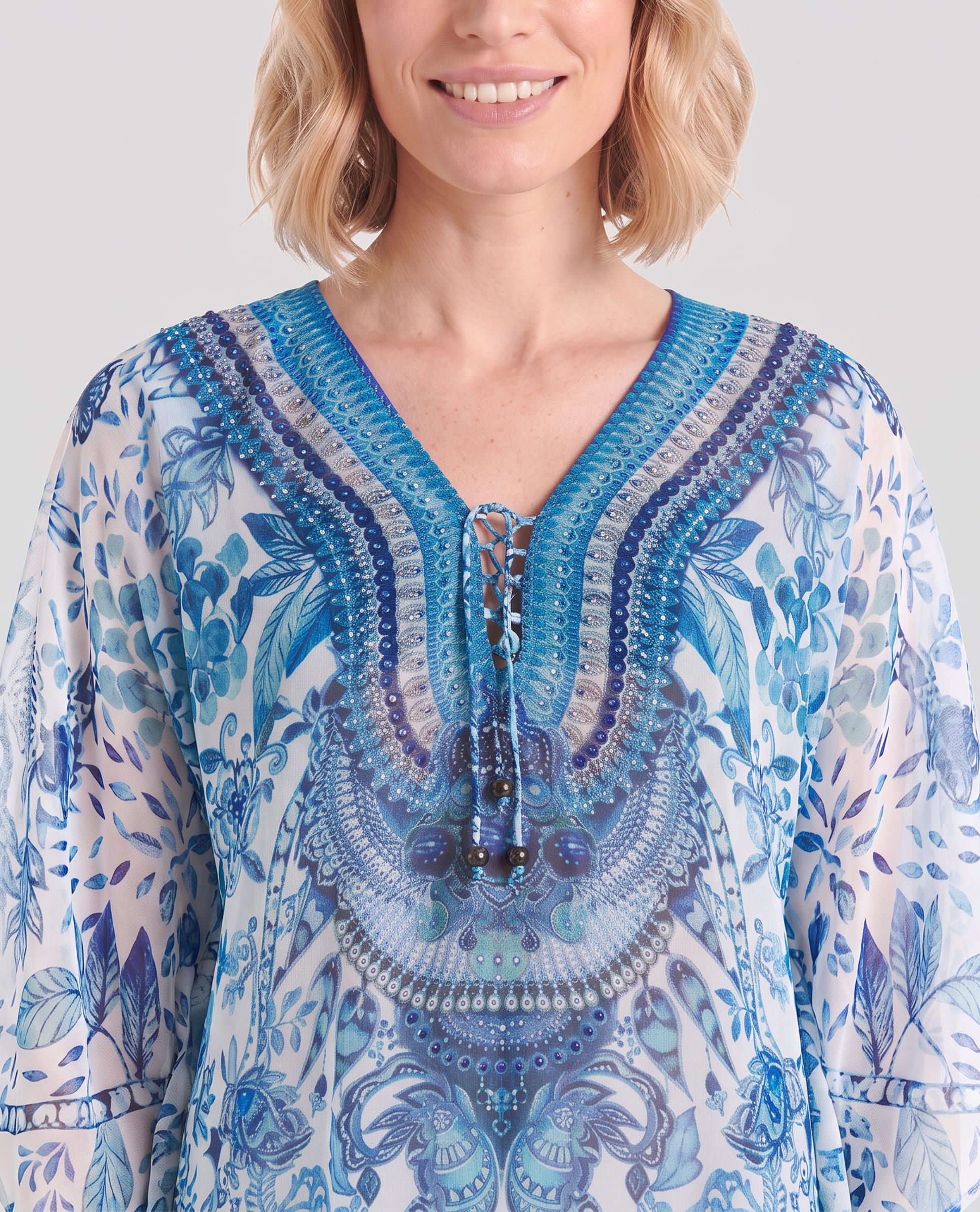 Vista detalle de cuello abierto de kaftan azul corto con pedrería