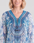 Vista detalle de cuello abierto de kaftan azul corto con pedrería