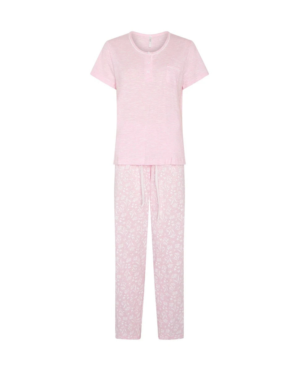 Pijama largo de mujer en punto, con camiseta flamé rosa de manga corta y cuello redondo con botones y pantalón estampado de florecitas blancas.