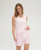 Modelo luce pijama corto de mujer rosa sin mangas estampado con florecitas y cinto rosa marfil