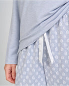 Detalle del pantalón largo estampado azul acero con hojas y lazo de raso en la cintura.