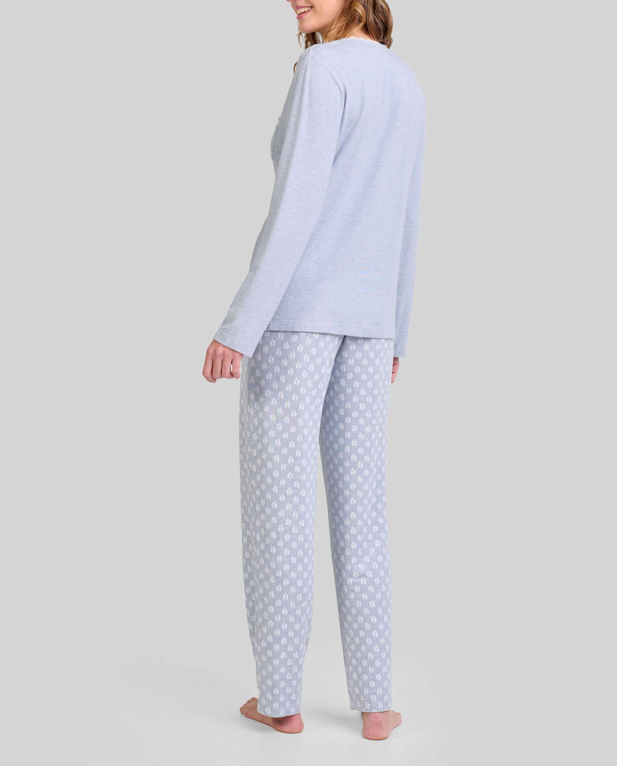 Vista trasera de mujer con pijama largo azul de manga larga azul