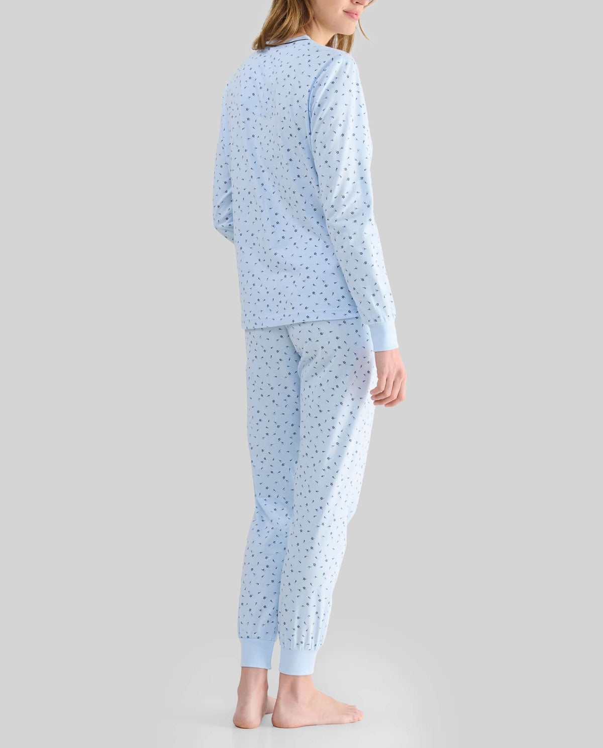 Mujer con pijama largo celeste estampado vista de espaldas