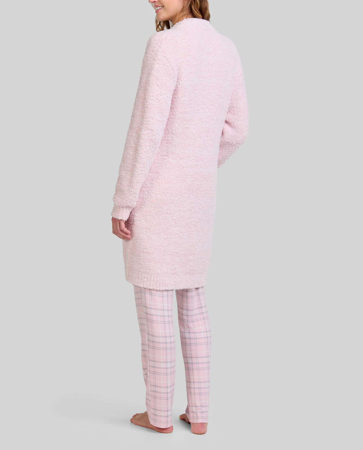 Vista trasera de mujer con bata larga de invierno rosa con bolsillos